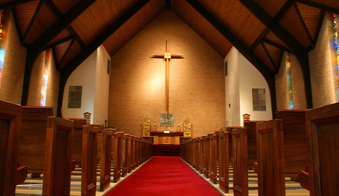 Church sanctuary interior with wooden pews and cross