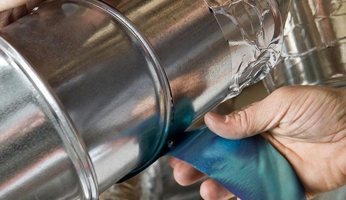 A person using duct tape to seal duct pipe Expert worker using duct tape to seal duct pipe