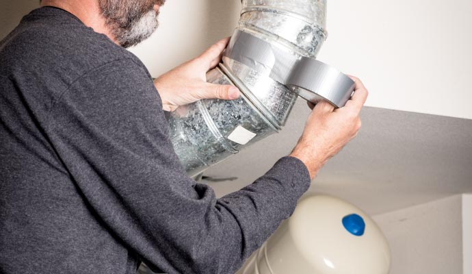 Technician sealing duct with duct tape Technician sealing duct with duct tape