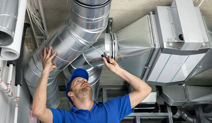 Professional HVAC technician performing ductwork maintenance and repair